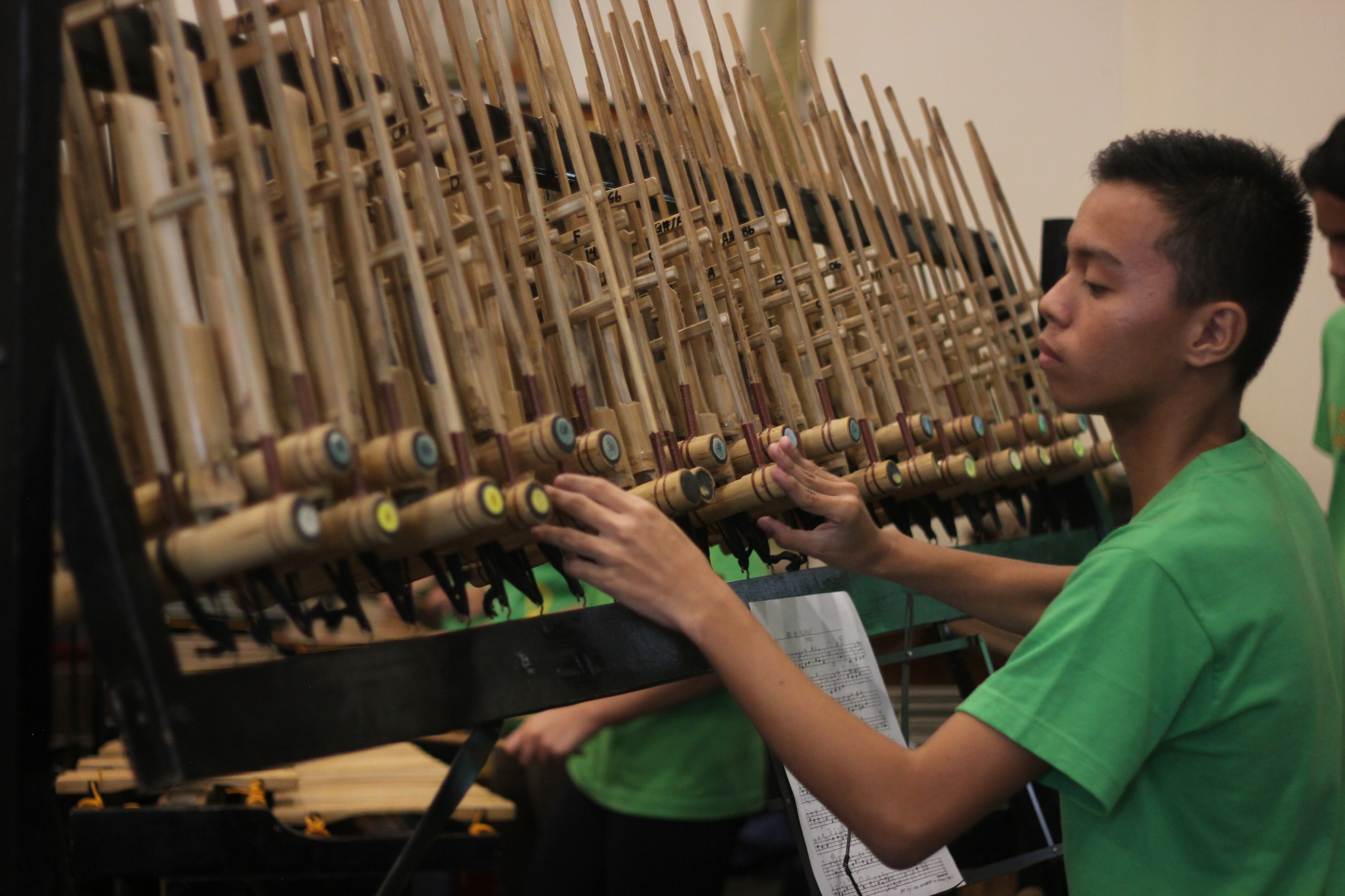 Members of the band play the tipangklung (above) and bumbong (below). Members of the band play the tipangklung (above) and bumbong (below).